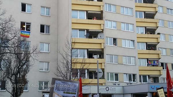 BewohnerInnen winken von oben der Demo #liesingfüralle zu.